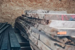 Une pile de planches de chênes bruts dans l'atelier de Veinage Création.